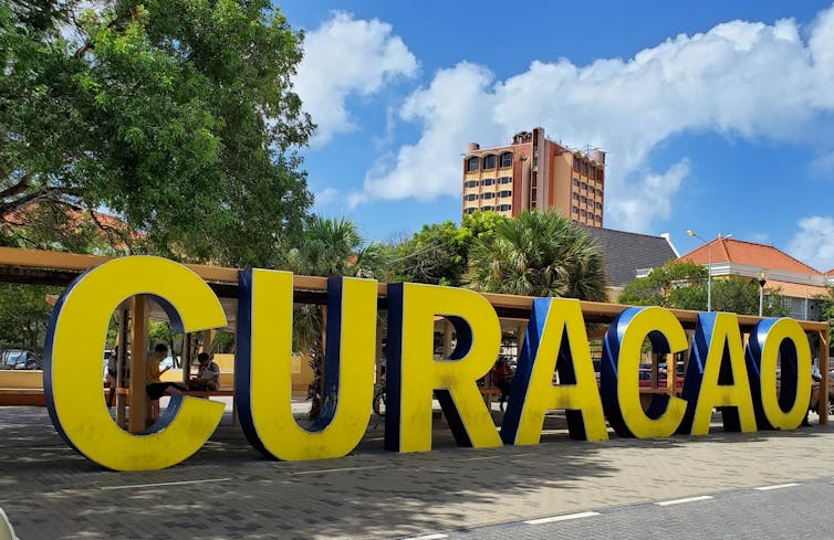 Street sign saying Curacao in big yellow letters