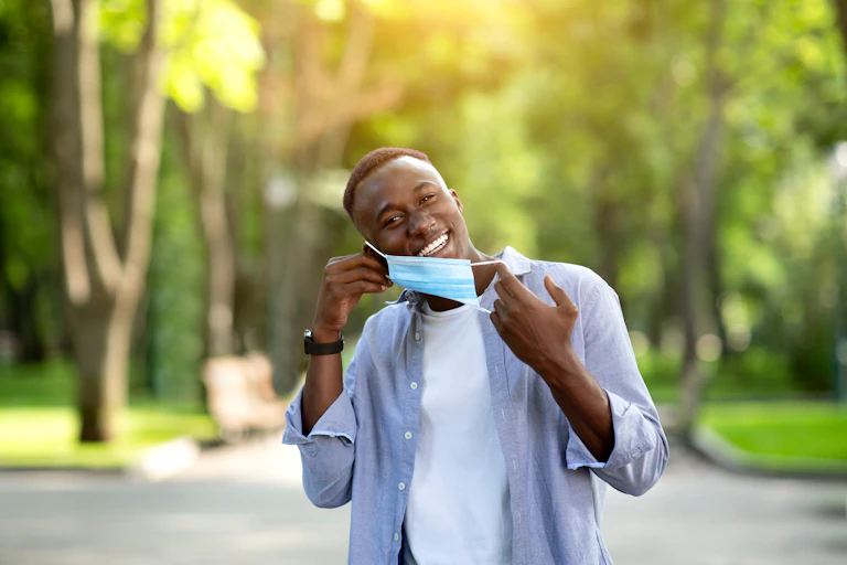 A man removes his mask.