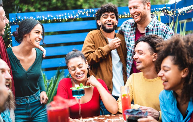 A group of young adults having drinks and socialising.