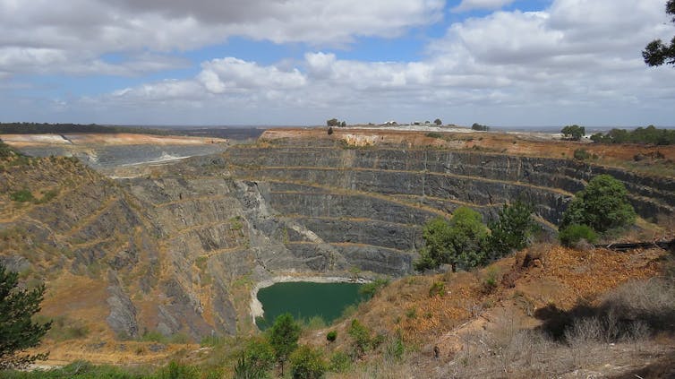 Une très grande mine à ciel ouvert, avec un lac au fond