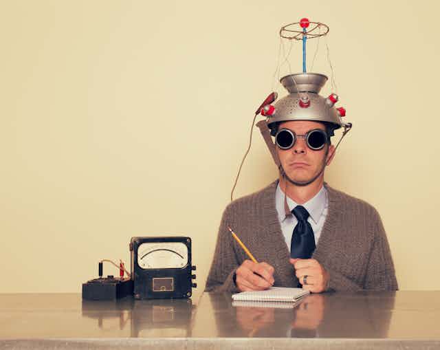 A man wearing a funny hat taking a test.