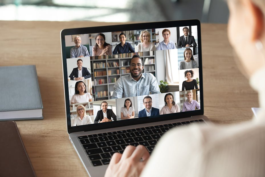A person out of frame in the foreground participating in an online meeting