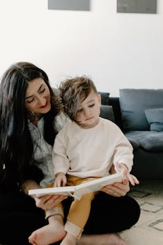 A woman seen reading to a child.