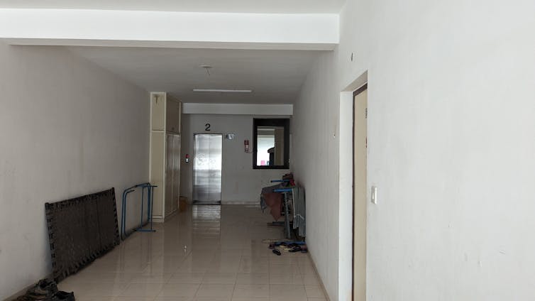 Corridor to access apartments from stair and lift painted white.