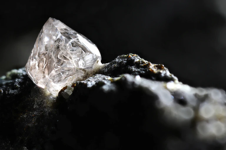 close-up of uncut diamond sitting on rock
