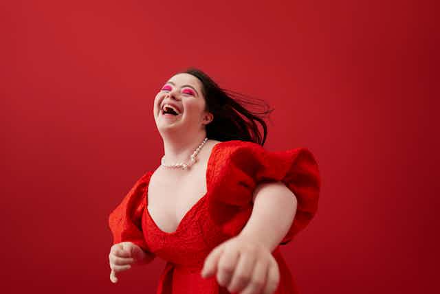 young woman with downs syndrome dances in red dress
