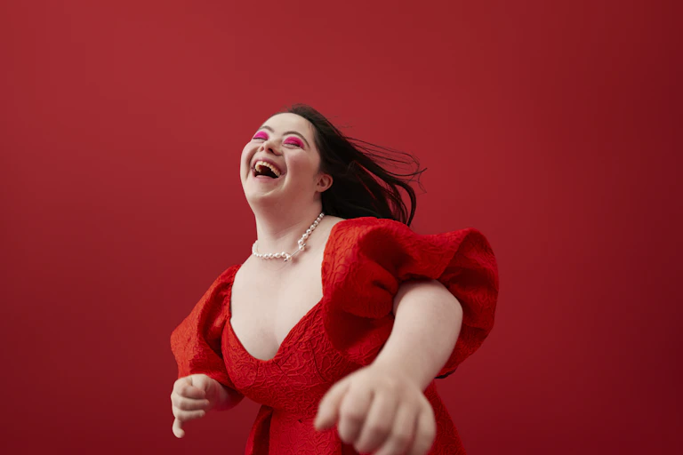 young woman with downs syndrome dances in red dress