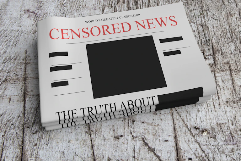 A pile of three newspapers titled Censored News, with blocks of black boxes on the front page