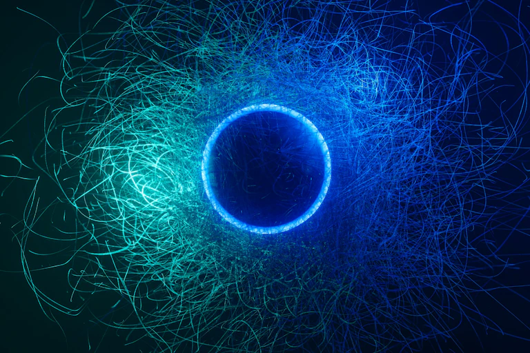 An abstract illustration showing a dark circle surrounded by a blue ring and a cloud of swarming blue and green lines.