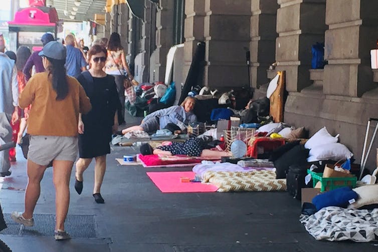 People sleeping rough on the pavement outside Flinders Street Station
