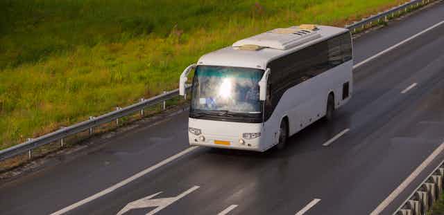 A bus drives along a rural highway