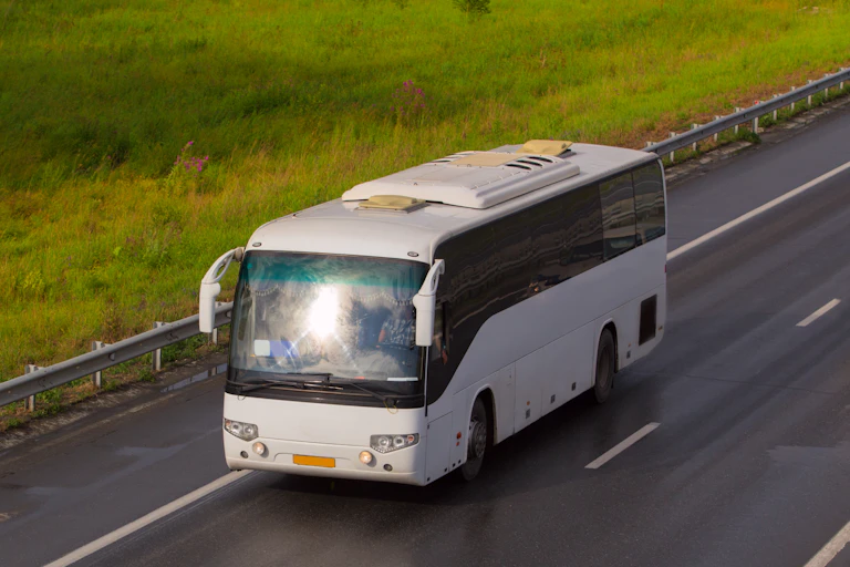 A bus drives along a rural highway