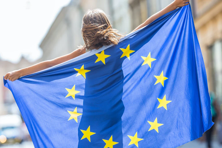 Jovencita de espaldas con la bandera de la Unión Europea.