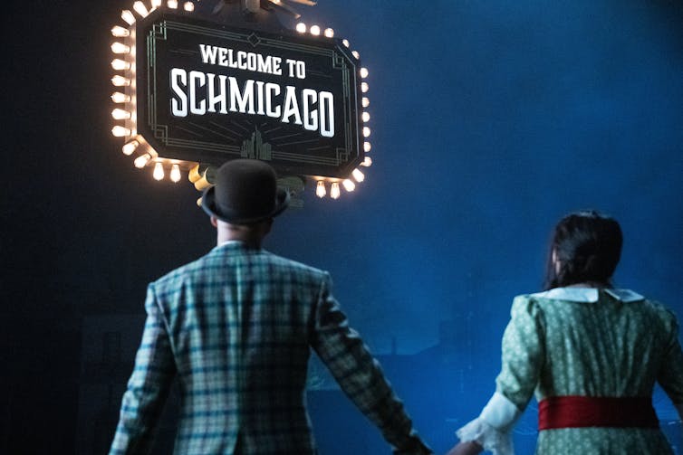 Keegan-Michael Key and Cecily Strong in Schmigadoon! looking at a sign than says Schmicago!