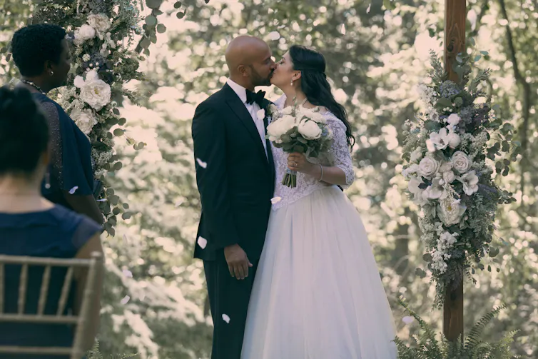 Josh and Melissa kiss at their wedding.
