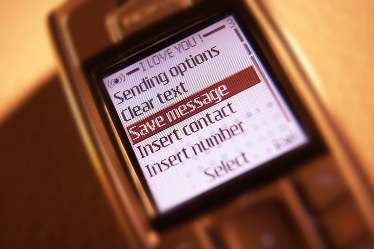 A 1990s-era smartphone displaying messaging options. 'Save message' is highlighted in the list of options.