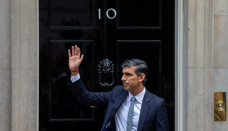 UK Prime Minister Rishi Sunak waving outside 10 Downing Street.