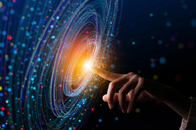 a hand reaching out to a swirling colourful pattern on a digital screen