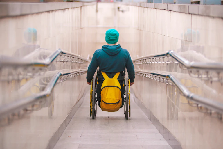 person in wheelchair travels down long ramp
