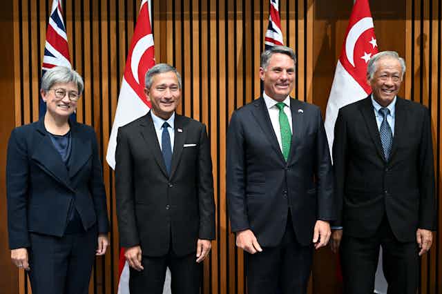Foreign Minister Penny Wong and Defence Minister Richard Marles posing for photos with their Singaporean counterparts