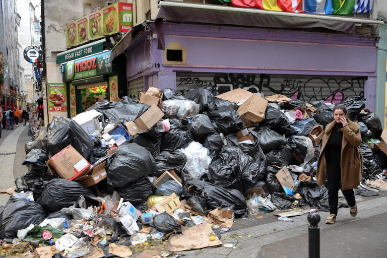 montagne de déchets et une personne qui passe à côté