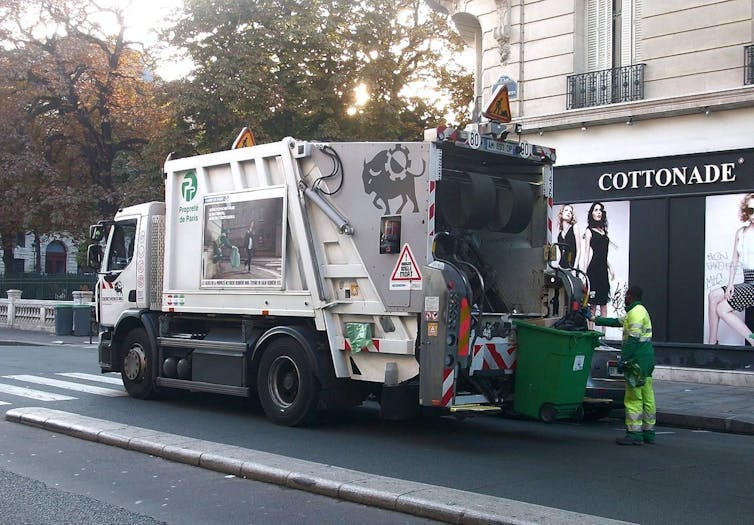 un éboueur derrière son camion dans les rues de paris