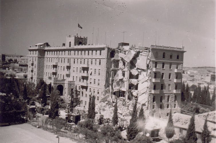 Black and white photo of large, bomb-damaged building