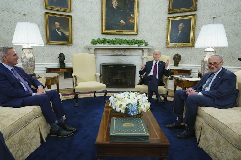 three white men sit on couches and chairs in an ornate room with pictures of past presidents on the wall