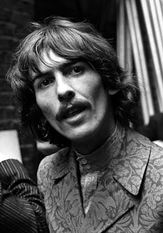 A black and white photo of George Harrison.