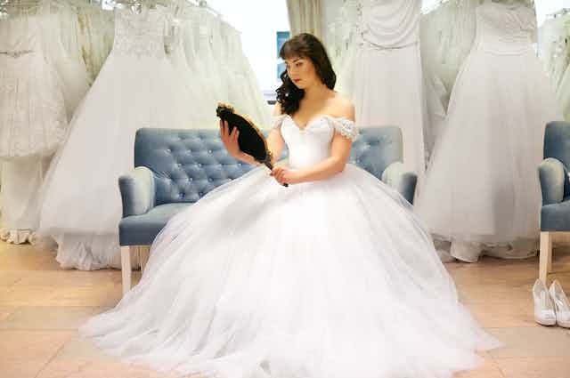 Bride in bridal shop looking in mirror