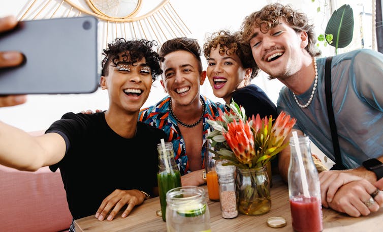 A group of young people at a table taking a selfie