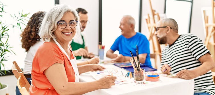 A group of middle-aged adults around a table at an art class