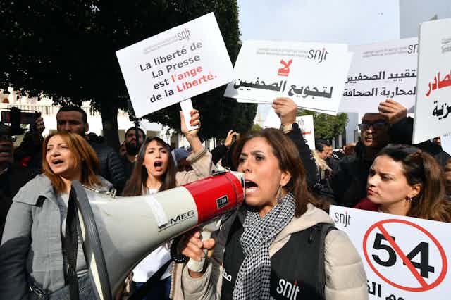 Des manifestants tunisiens brandissent des pancartes dans les rue de Tunis pour défendre la liberté d'expression et condamner la persécution des journalistes.