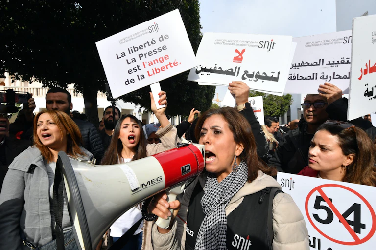 Des manifestants tunisiens brandissent des pancartes dans les rue de Tunis pour défendre la liberté d'expression et condamner la persécution des journalistes.