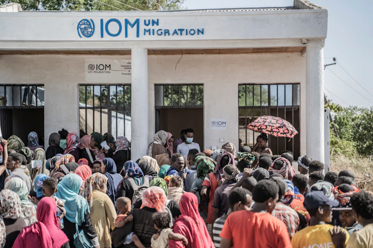 People wait in line in front of a building