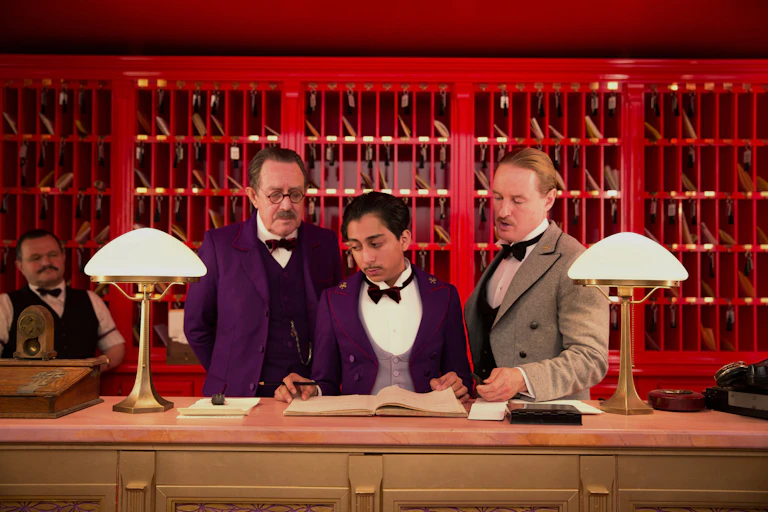 Three men behind a hotel check-in desk