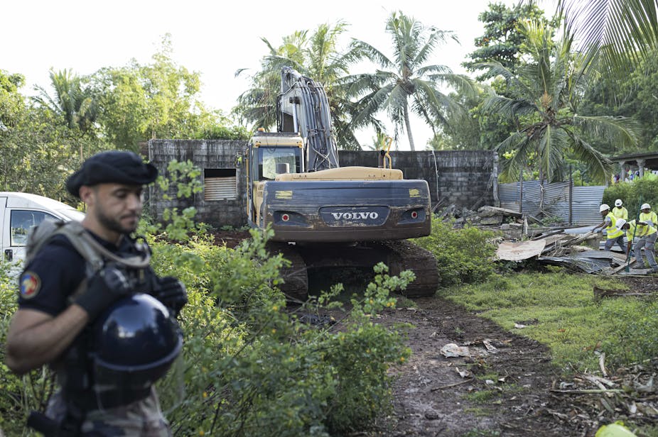 Un gendarme français monte la garde lors de la démolition d'un campement informel à Longoni, Mamoudzou, sur l'île de Mayotte, le 27 avril 2023.