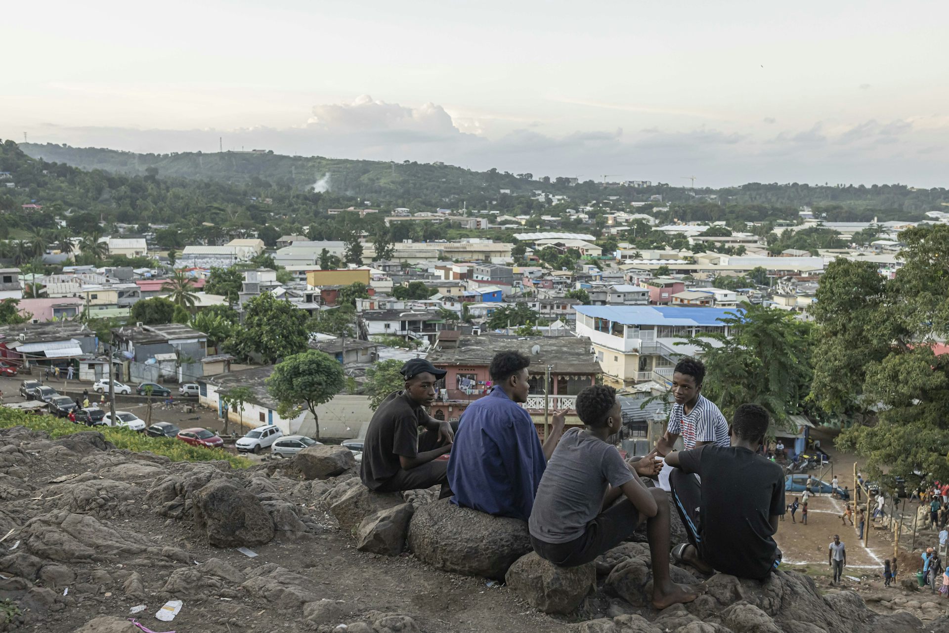 Des garçons discutent assis sur une colline surplombant le village de Kaweni, près de Mamoudzou, sur l’île de Mayotte, le 26 avril 2023