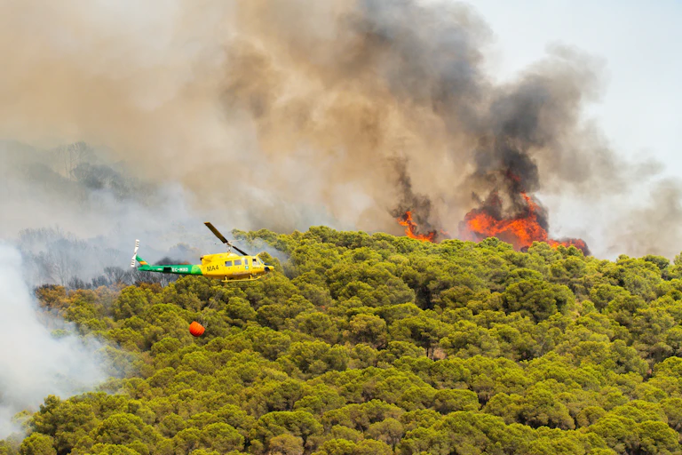 Helicóptero aproximándose a un incendio forestal.