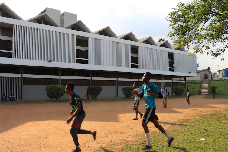 A building with boys playing in the foreground.