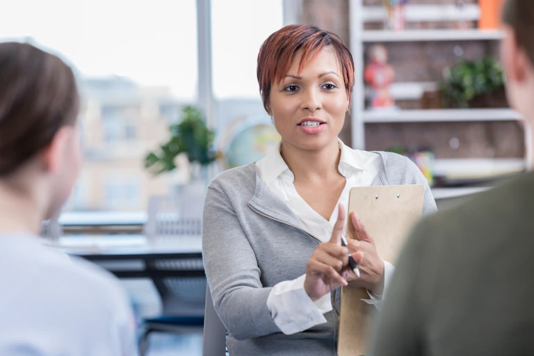 A woman meets with two individuals.