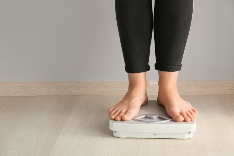 A woman standing on scales.