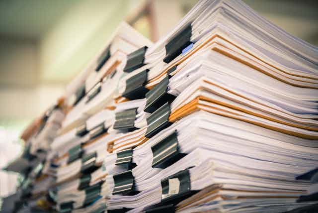 Piles of stacked papers, held with bulldog clips