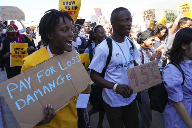 Climate protesters march holding placards