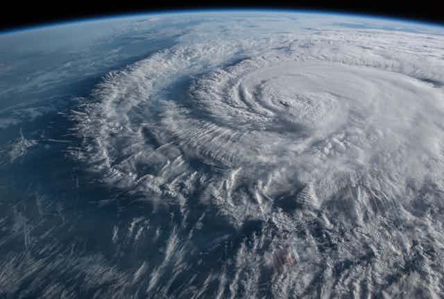 A hurricane and its outer bands seen from space, with the edge of the space station visible.