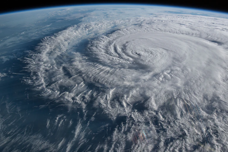 A hurricane and its outer bands seen from space, with the edge of the space station visible.