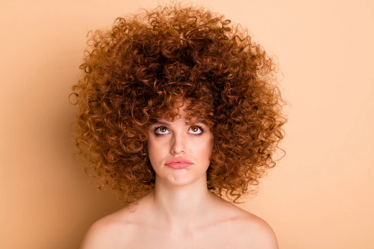 Women looking up at her big curly hair do