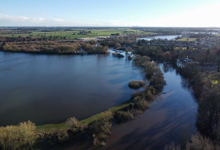 Uma vista aérea de um campo inundado com uma cidade próxima.
