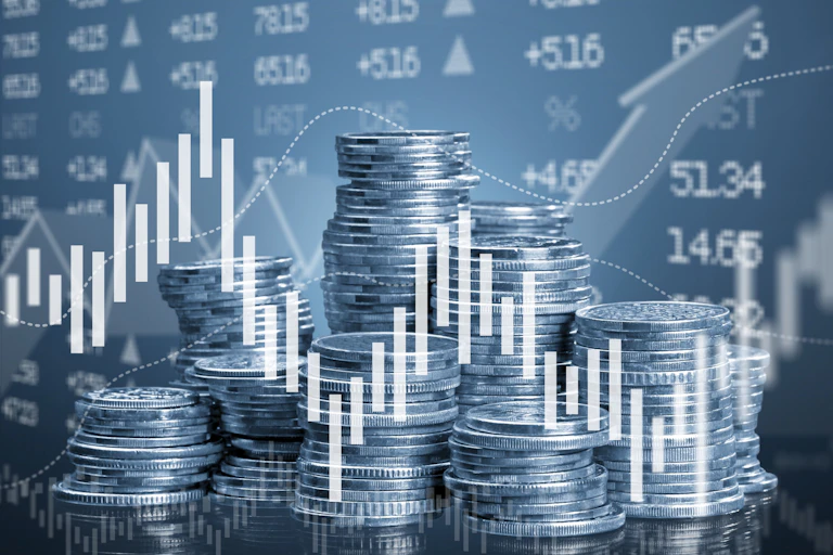 Piles of coins with graph and share price background.