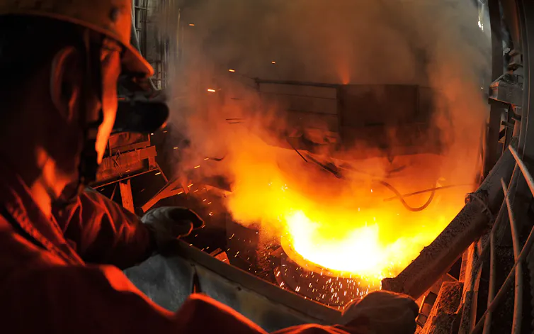 man stands beside furnace